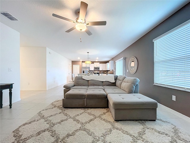 tiled living room featuring a textured ceiling and ceiling fan