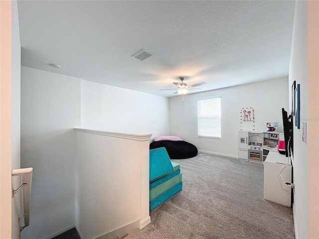 bedroom featuring ceiling fan, carpet floors, and a textured ceiling