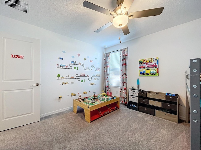 rec room with ceiling fan, carpet floors, and a textured ceiling