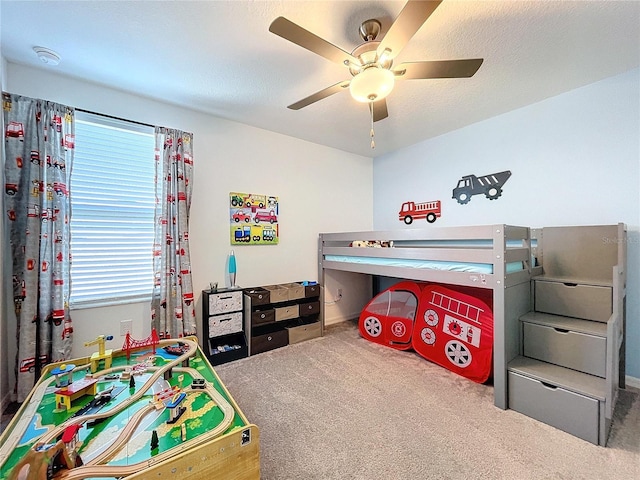 carpeted bedroom with ceiling fan and a textured ceiling