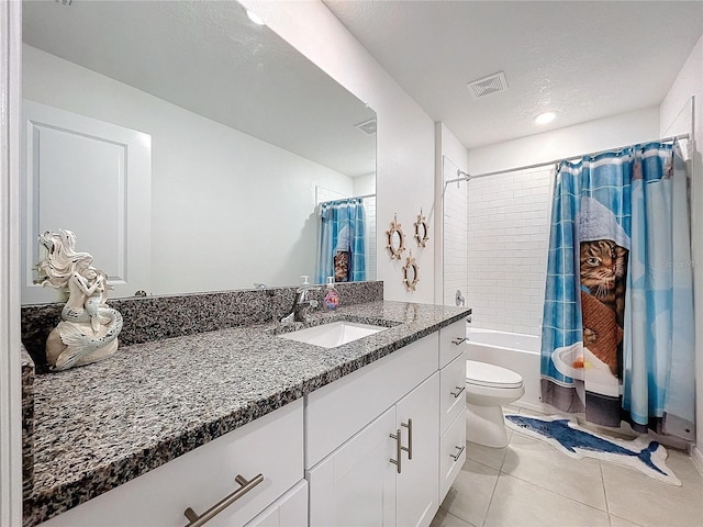 full bathroom featuring tile patterned floors, a textured ceiling, toilet, shower / tub combo with curtain, and vanity