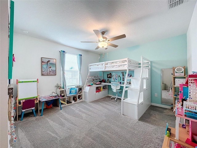 carpeted bedroom featuring ceiling fan and a textured ceiling