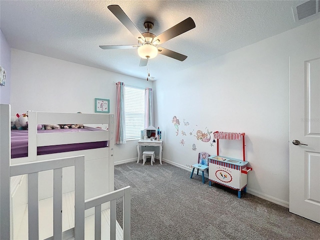 bedroom with ceiling fan, carpet, and a textured ceiling