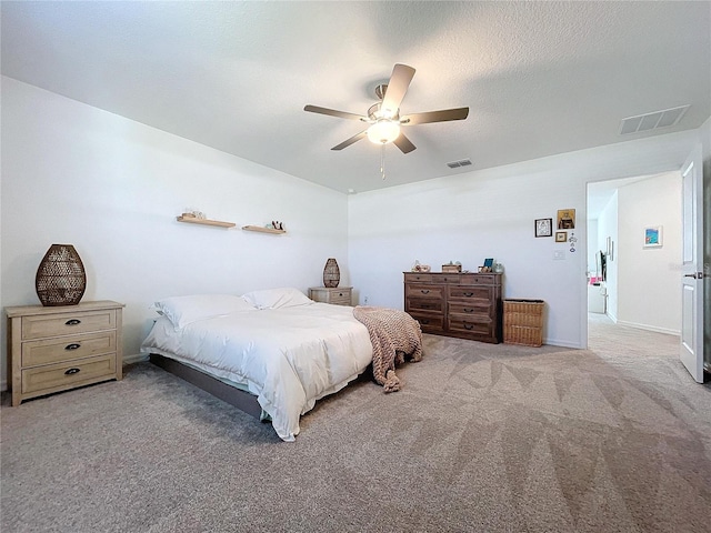 carpeted bedroom featuring a textured ceiling and ceiling fan