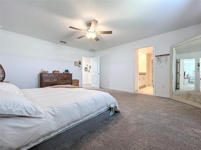 carpeted bedroom featuring a textured ceiling, ceiling fan, and ensuite bathroom