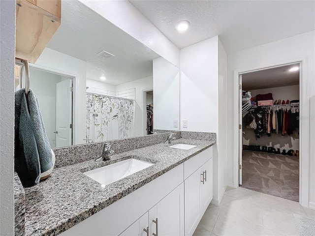 bathroom featuring tile patterned flooring, vanity, a textured ceiling, and a shower with shower curtain