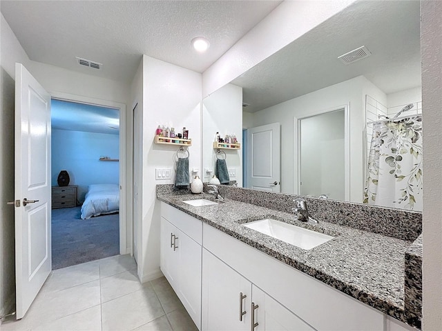 bathroom featuring tile patterned floors, vanity, curtained shower, and a textured ceiling