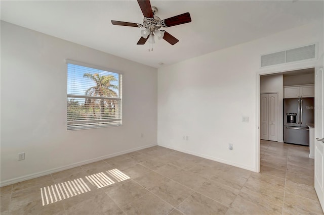 tiled empty room featuring ceiling fan