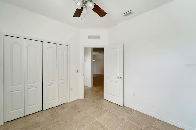 unfurnished bedroom with light tile patterned floors, ceiling fan, and a closet