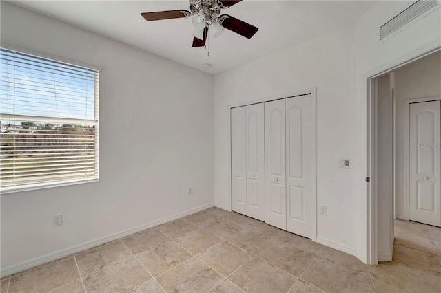 unfurnished bedroom with light tile patterned floors, ceiling fan, and a closet