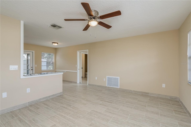 unfurnished room featuring ceiling fan and a textured ceiling