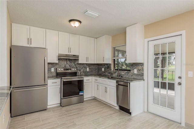 kitchen featuring stone counters, white cabinetry, sink, and appliances with stainless steel finishes