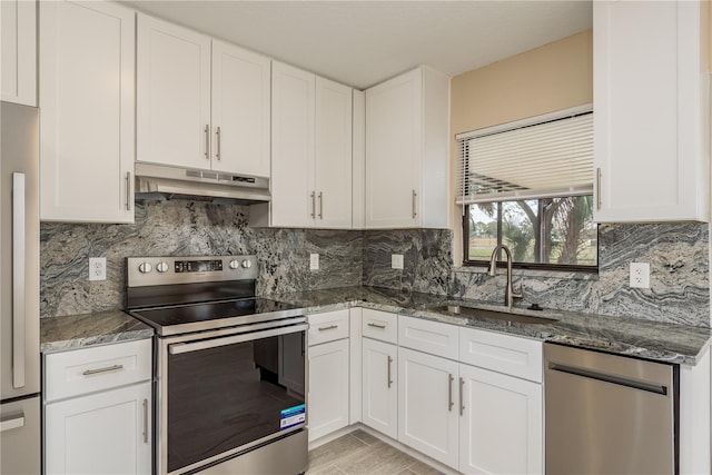 kitchen with white cabinets, dark stone counters, sink, and appliances with stainless steel finishes