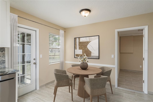 dining space featuring light hardwood / wood-style floors and a textured ceiling