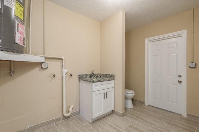 bathroom featuring toilet, vanity, and a textured ceiling