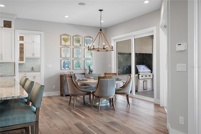 dining room featuring light hardwood / wood-style floors, sink, and a chandelier