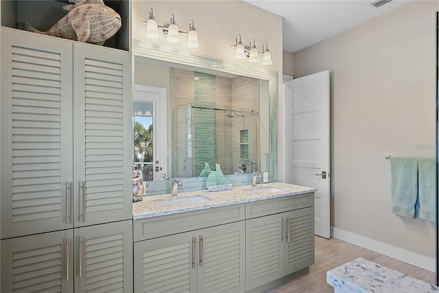 bathroom with vanity, hardwood / wood-style flooring, and a shower with door