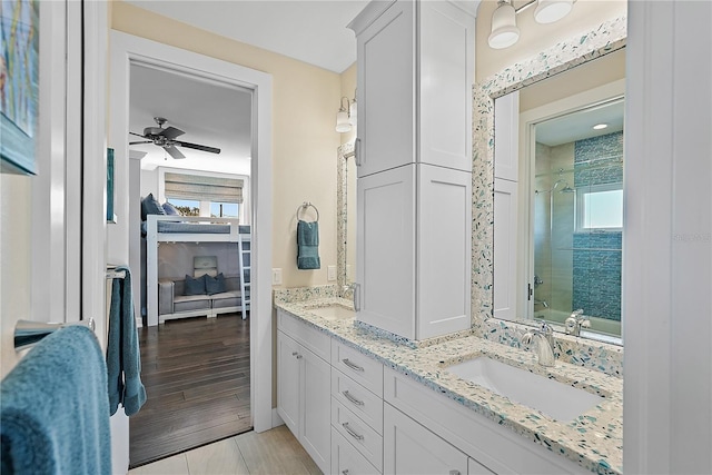 bathroom with ceiling fan, vanity, and tiled shower / bath combo