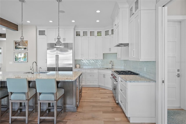 kitchen featuring white cabinets, sink, pendant lighting, high quality appliances, and beamed ceiling