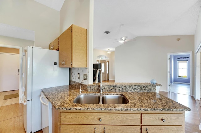 kitchen featuring stone countertops, sink, ceiling fan, light hardwood / wood-style flooring, and lofted ceiling