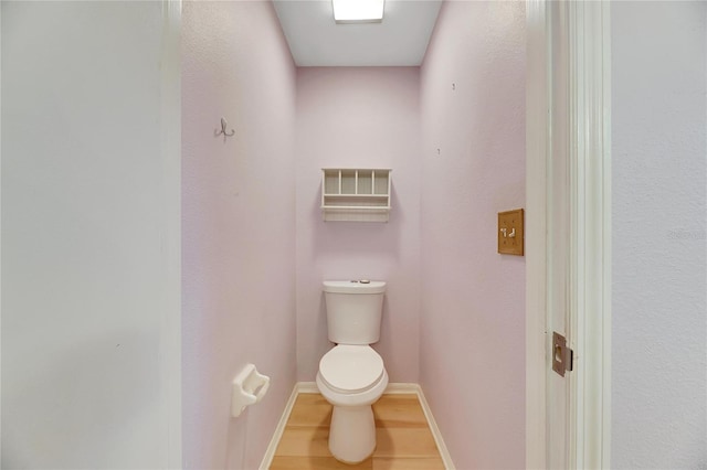 bathroom featuring wood-type flooring and toilet