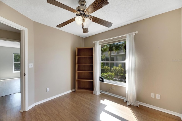 spare room featuring ceiling fan, a textured ceiling, and light hardwood / wood-style floors