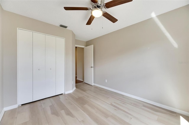 unfurnished bedroom with ceiling fan, a textured ceiling, a closet, and light hardwood / wood-style flooring