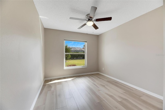 empty room featuring light hardwood / wood-style floors, ceiling fan, and a textured ceiling