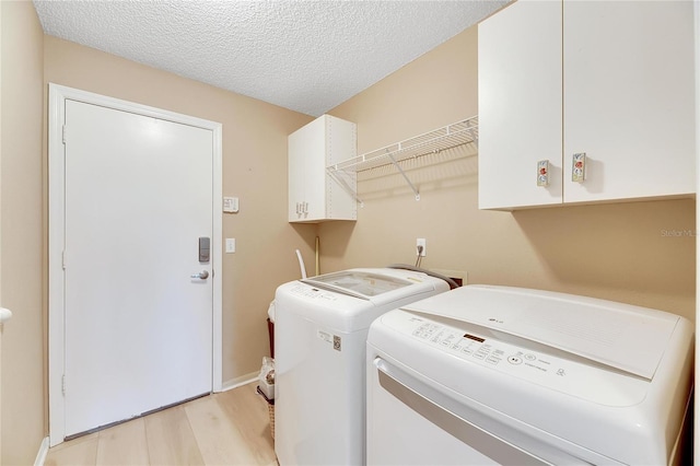 719 Winterbrooke Way, Sun City Center, FL 33573 - laundry room with washer and dryer, light wood-style floors, cabinet space, baseboards, and a textured ceiling