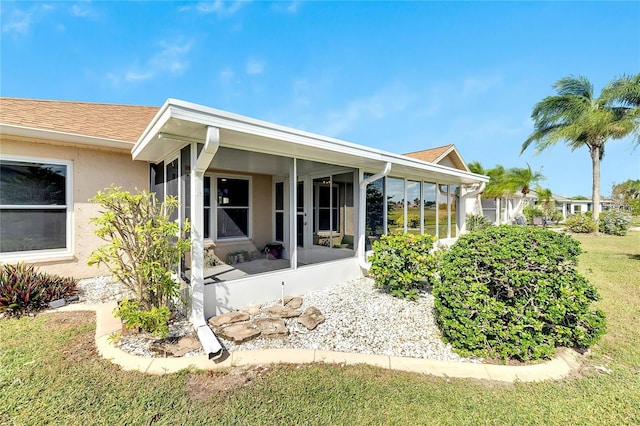 719 Winterbrooke Way, Sun City Center, FL 33573 - rear view of property featuring a sunroom, stucco siding, and roof with shingles