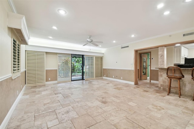 unfurnished living room featuring ceiling fan and ornamental molding