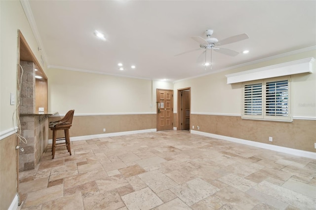 interior space with bar, ceiling fan, and crown molding