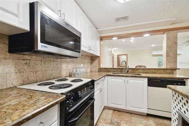 kitchen featuring dark stone counters, sink, crown molding, white cabinetry, and white appliances