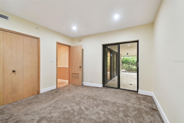 unfurnished bedroom featuring a closet, access to outside, and carpet floors