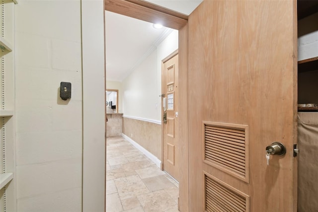 hallway with wooden walls and crown molding