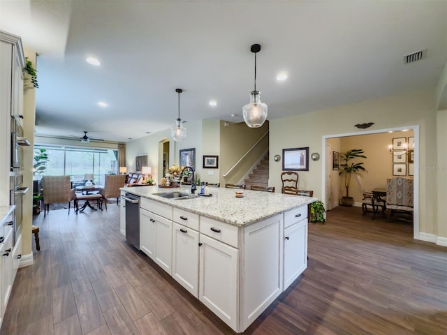 kitchen featuring white cabinets, sink, an island with sink, dark hardwood / wood-style floors, and decorative light fixtures