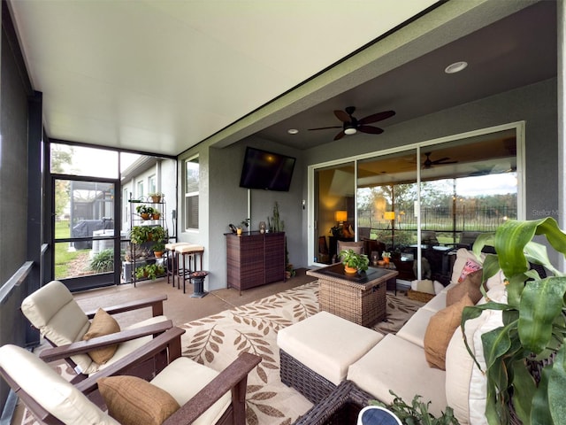 sunroom / solarium featuring ceiling fan and plenty of natural light