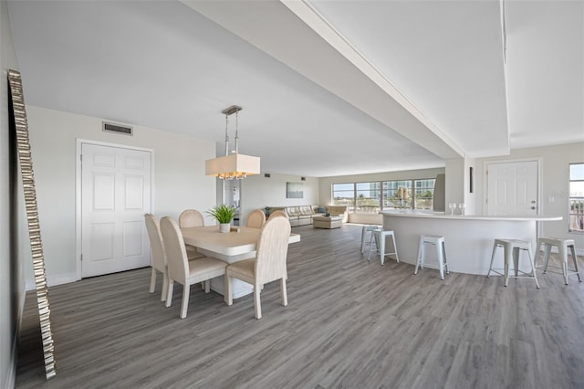 dining space with hardwood / wood-style floors and a notable chandelier