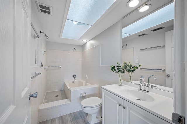 full bathroom featuring shower with separate bathtub, toilet, tile walls, hardwood / wood-style floors, and vanity