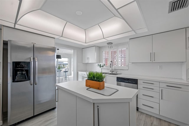 kitchen featuring a kitchen island, appliances with stainless steel finishes, a healthy amount of sunlight, and white cabinets