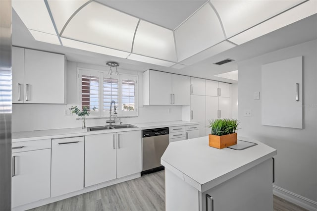 kitchen featuring sink, stainless steel dishwasher, light hardwood / wood-style flooring, a center island, and white cabinets