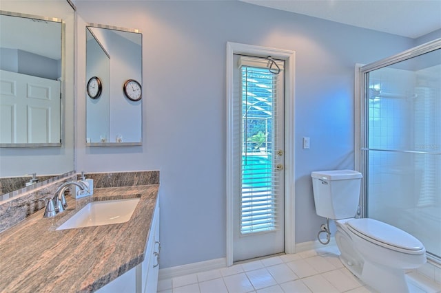 bathroom with tile patterned floors, toilet, a shower with door, and a wealth of natural light