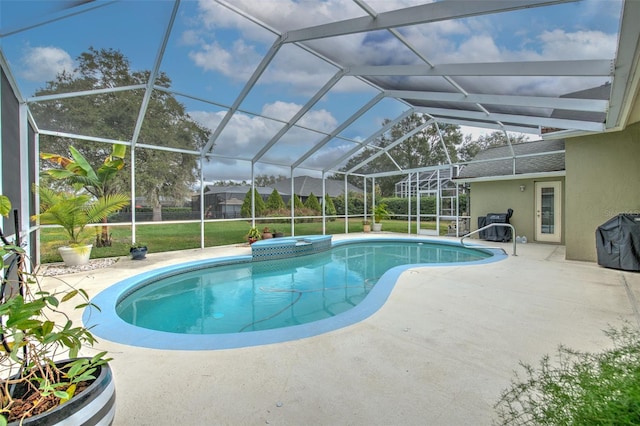 view of pool featuring a lawn, a patio area, and glass enclosure