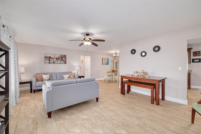 living room featuring ceiling fan with notable chandelier