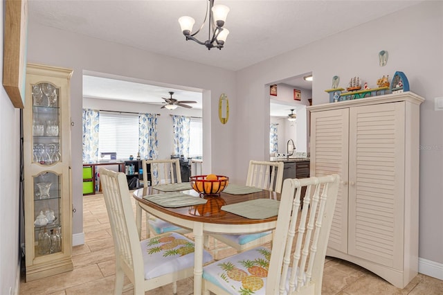 dining area with light tile patterned floors and ceiling fan with notable chandelier