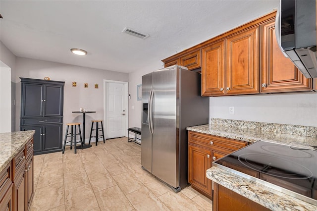 kitchen featuring light stone countertops and stainless steel appliances