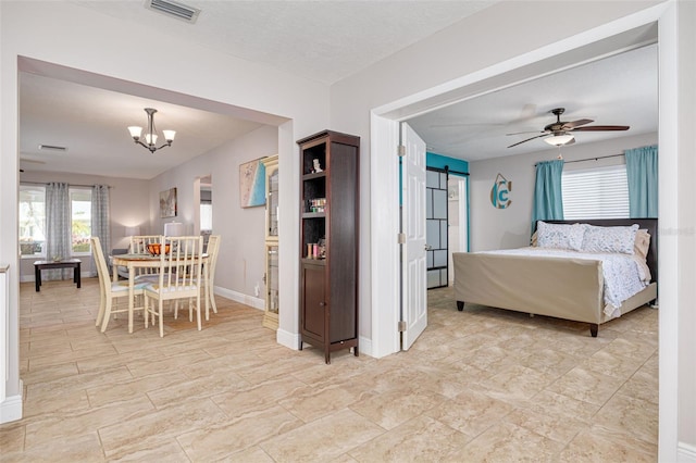 bedroom with a textured ceiling and ceiling fan with notable chandelier