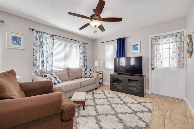 tiled living room featuring a wealth of natural light, ceiling fan, and a textured ceiling