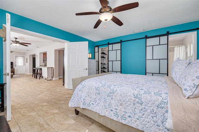 bedroom featuring a barn door and ceiling fan