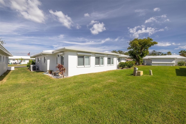 back of property with a yard and central AC unit